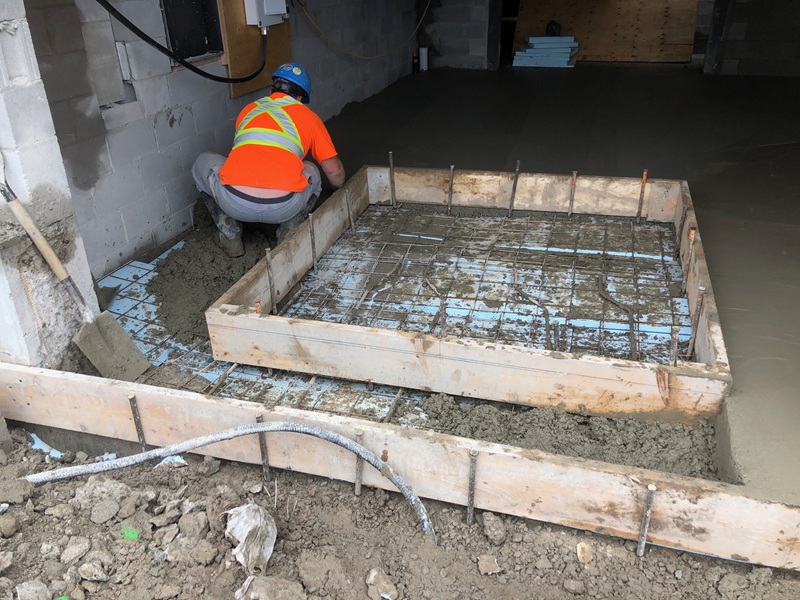 Worker preparing concrete slab formwork and steel reinforcement